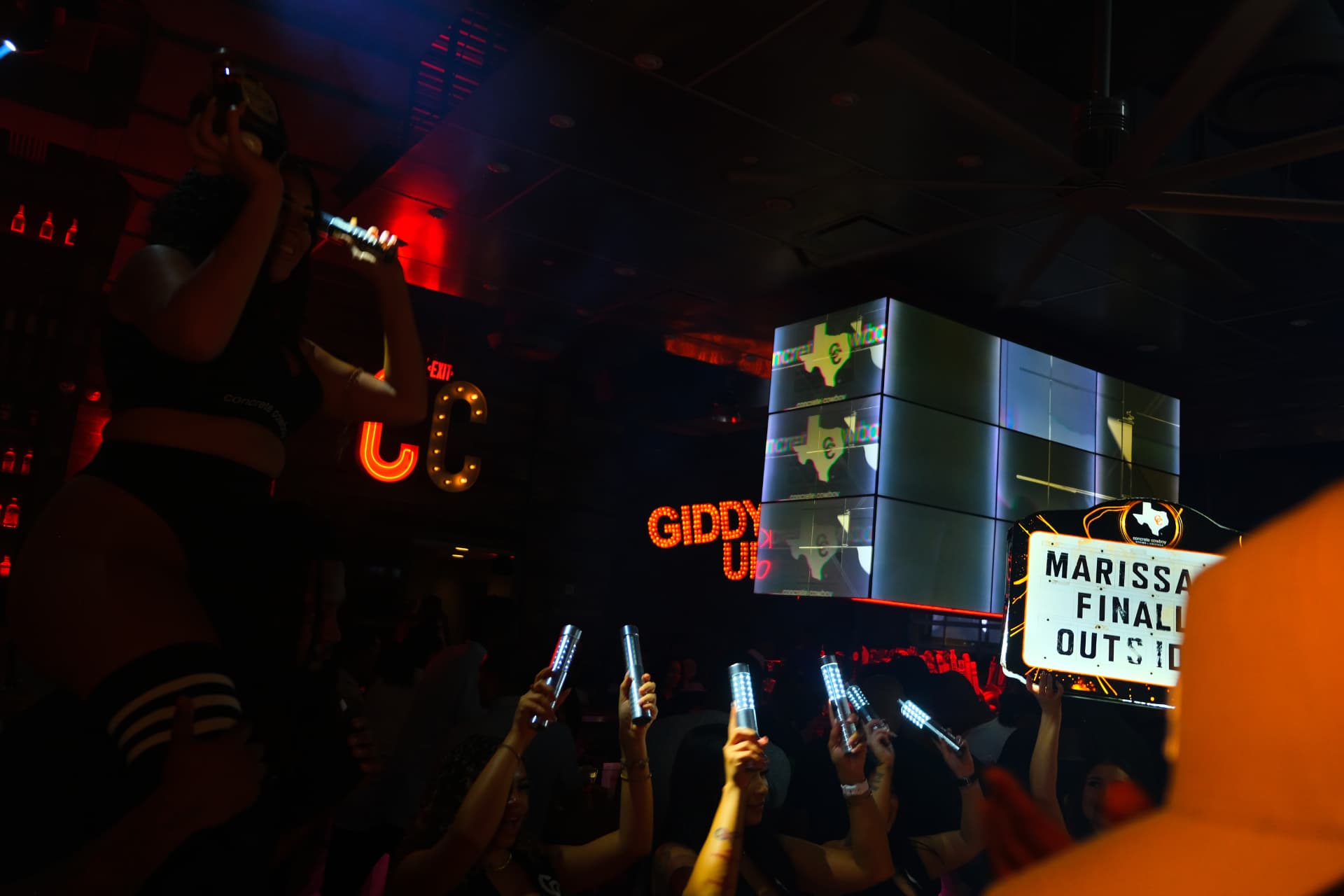 Crowd under the GIDDY UP marquee at Concrete Cowboy